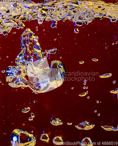 Image of Close up view of the cold and fresh cola with bright bubbles in neon light