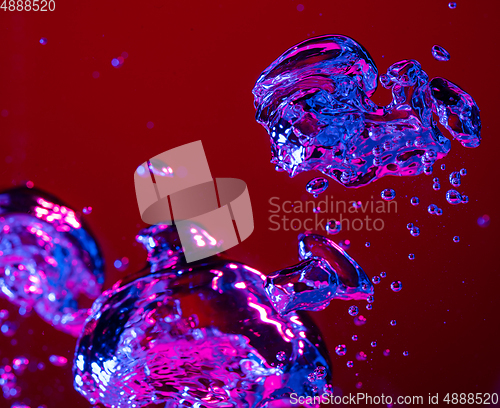 Image of Close up view of the cold and fresh cola with bright bubbles in neon light