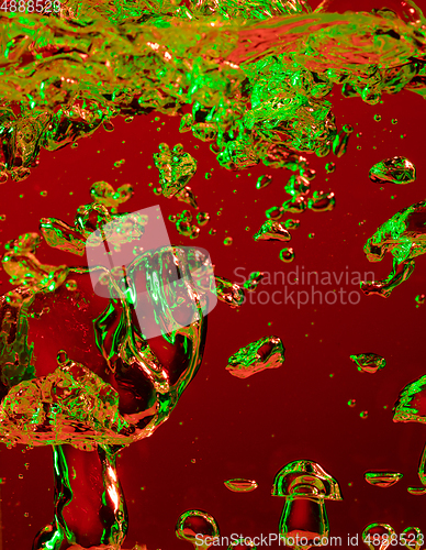 Image of Close up view of the cold and fresh cola with bright bubbles in neon light