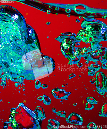 Image of Close up view of the cold and fresh cola with bright bubbles in neon light