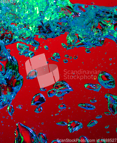 Image of Close up view of the cold and fresh cola with bright bubbles in neon light