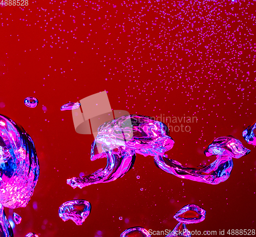 Image of Close up view of the cold and fresh cola with bright bubbles in neon light