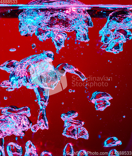Image of Close up view of the cold and fresh cola with bright bubbles in neon light