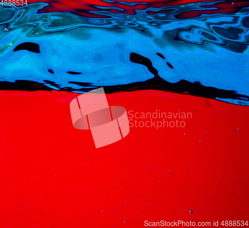 Image of Close up view of the cold and fresh cola with bright bubbles in neon light