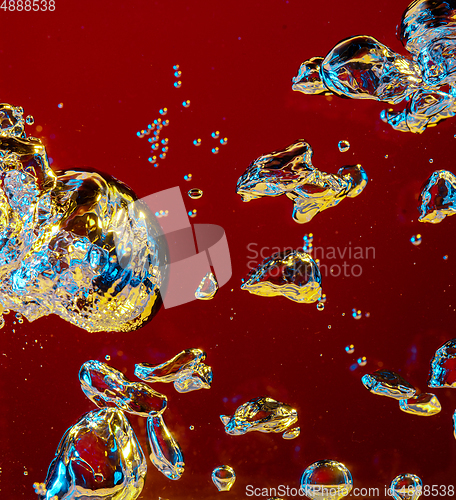 Image of Close up view of the cold and fresh cola with bright bubbles in neon light