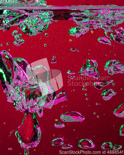 Image of Close up view of the cold and fresh cola with bright bubbles in neon light