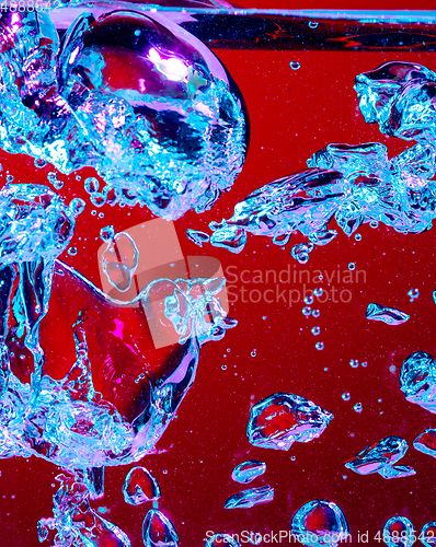 Image of Close up view of the cold and fresh cola with bright bubbles in neon light