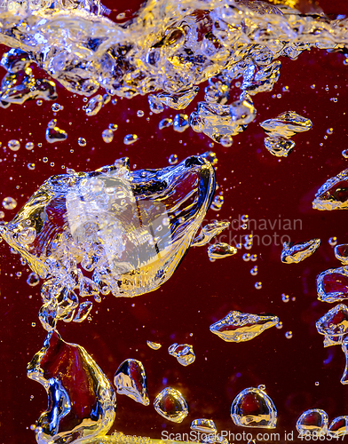 Image of Close up view of the cold and fresh cola with bright bubbles in neon light