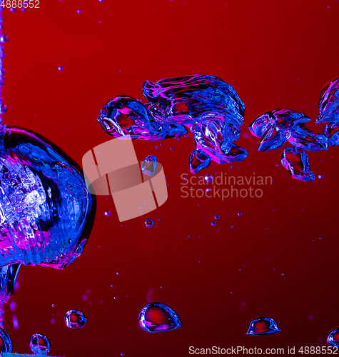 Image of Close up view of the cold and fresh cola with bright bubbles in neon light