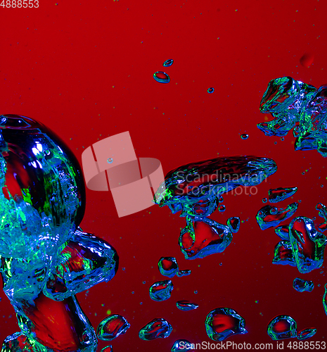 Image of Close up view of the cold and fresh cola with bright bubbles in neon light