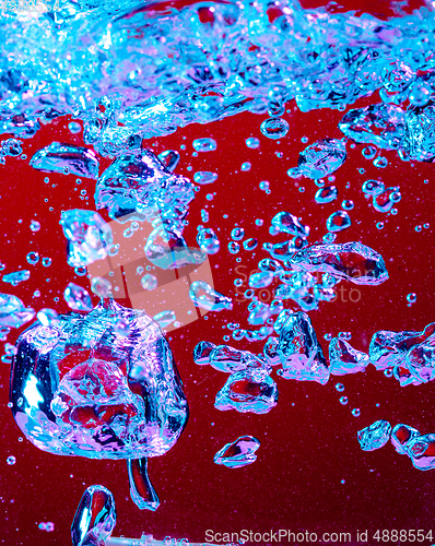 Image of Close up view of the cold and fresh cola with bright bubbles in neon light