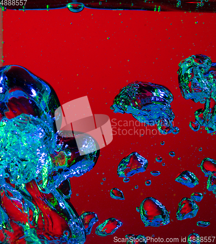 Image of Close up view of the cold and fresh cola with bright bubbles in neon light