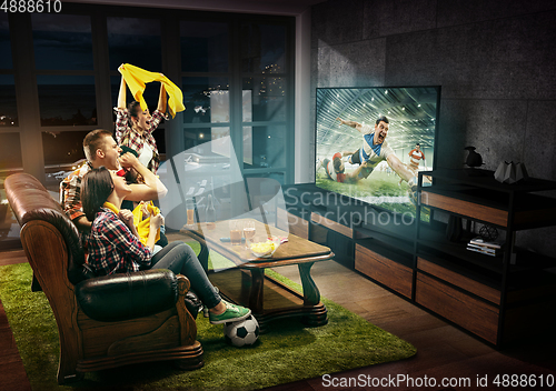 Image of Group of friends watching rugby match, sport together