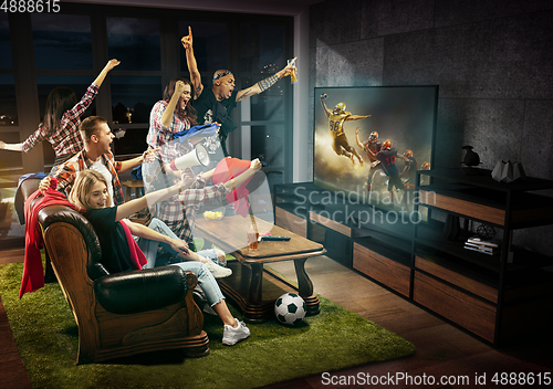 Image of Group of friends watching TV, american football match, sport together