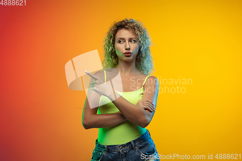 Image of Caucasian young woman\'s portrait on gradient studio background in neon