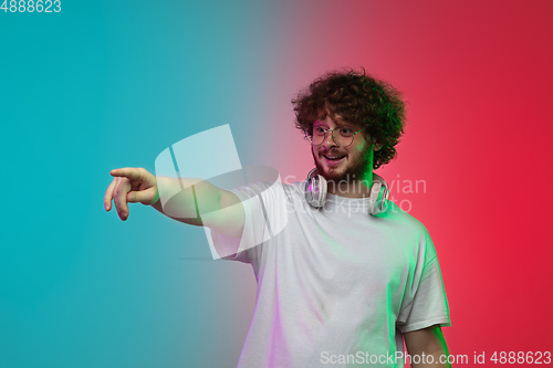 Image of Caucasian young man\'s portrait on gradient studio background in neon