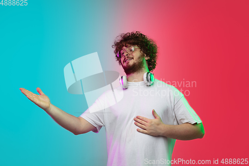 Image of Caucasian young man\'s portrait on gradient studio background in neon