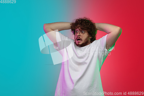 Image of Caucasian young man\'s portrait on gradient studio background in neon