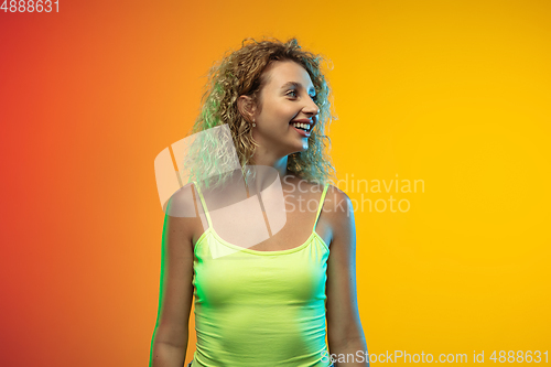 Image of Caucasian young woman\'s portrait on gradient studio background in neon