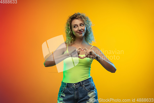 Image of Caucasian young woman\'s portrait on gradient studio background in neon
