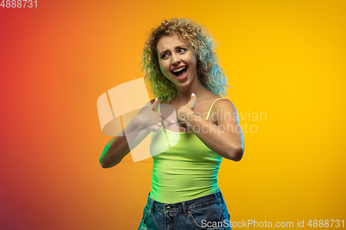 Image of Caucasian young woman\'s portrait on gradient studio background in neon