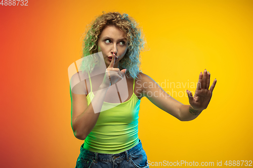 Image of Caucasian young woman\'s portrait on gradient studio background in neon