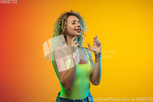 Image of Caucasian young woman\'s portrait on gradient studio background in neon