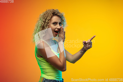 Image of Caucasian young woman\'s portrait on gradient studio background in neon