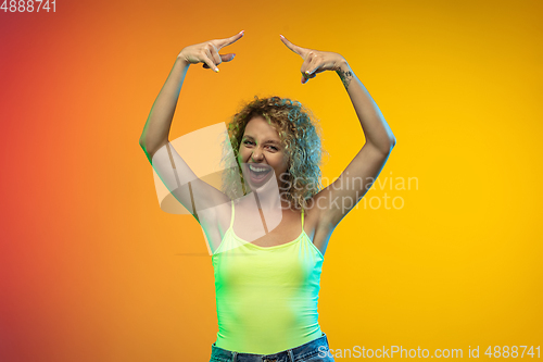 Image of Caucasian young woman\'s portrait on gradient studio background in neon