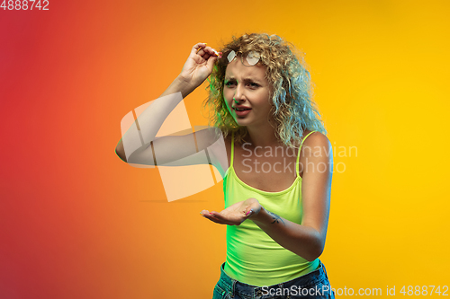 Image of Caucasian young woman\'s portrait on gradient studio background in neon