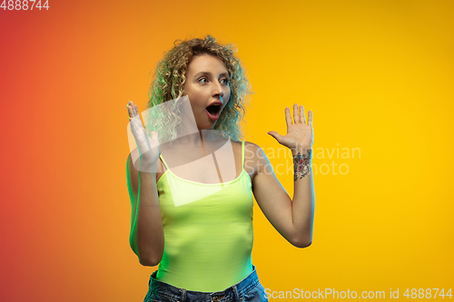 Image of Caucasian young woman\'s portrait on gradient studio background in neon
