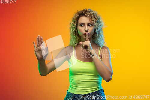 Image of Caucasian young woman\'s portrait on gradient studio background in neon