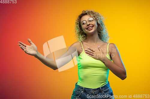 Image of Caucasian young woman\'s portrait on gradient studio background in neon