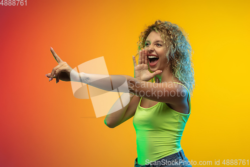 Image of Caucasian young woman\'s portrait on gradient studio background in neon