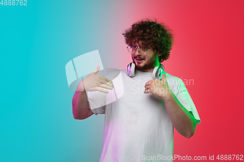 Image of Caucasian young man\'s portrait on gradient studio background in neon