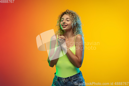 Image of Caucasian young woman\'s portrait on gradient studio background in neon