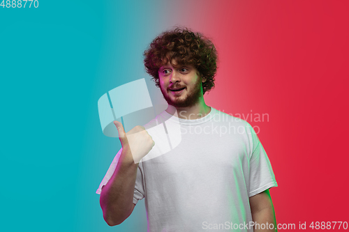 Image of Caucasian young man\'s portrait on gradient studio background in neon