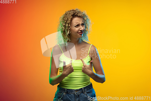 Image of Caucasian young woman\'s portrait on gradient studio background in neon