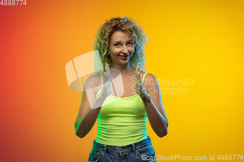 Image of Caucasian young woman\'s portrait on gradient studio background in neon