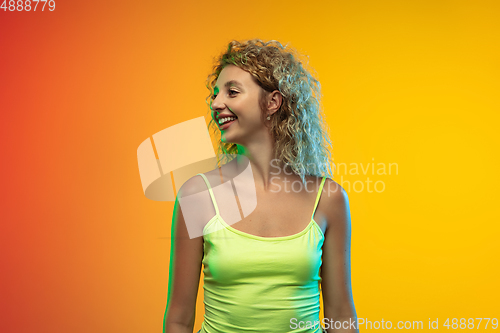 Image of Caucasian young woman\'s portrait on gradient studio background in neon