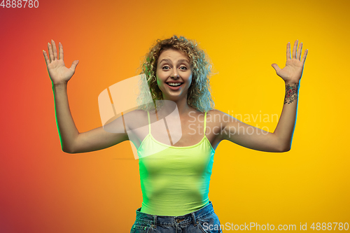 Image of Caucasian young woman\'s portrait on gradient studio background in neon