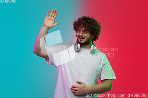 Image of Caucasian young man\'s portrait on gradient studio background in neon