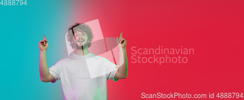 Image of Caucasian young man\'s portrait on gradient studio background in neon