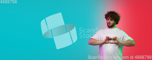 Image of Caucasian young man\'s portrait on gradient studio background in neon