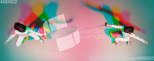 Image of Teen girl in fencing costume with sword in hand on gradient background with neon light, top view