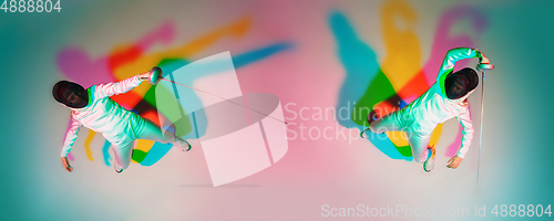 Image of Teen girl in fencing costume with sword in hand on gradient background with neon light, top view