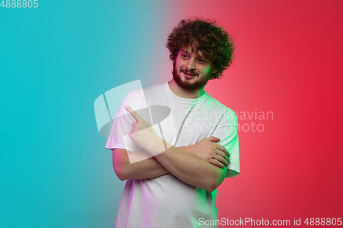 Image of Caucasian young man\'s portrait on gradient studio background in neon