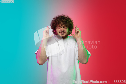 Image of Caucasian young man\'s portrait on gradient studio background in neon