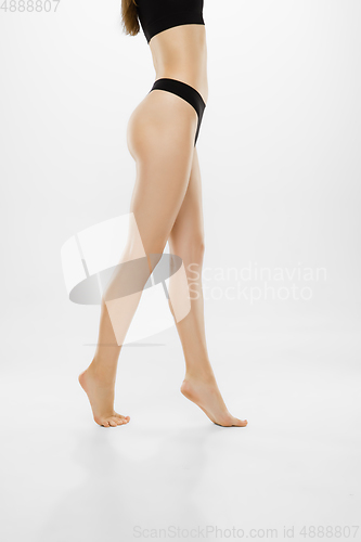 Image of Beautiful female legs and belly isolated on white background. Beauty, cosmetics, spa, depilation, treatment and fitness concept.
