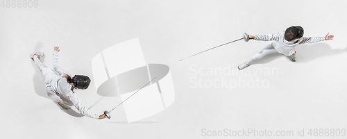 Image of Teen girl in fencing costume with sword in hand isolated on white background, top view